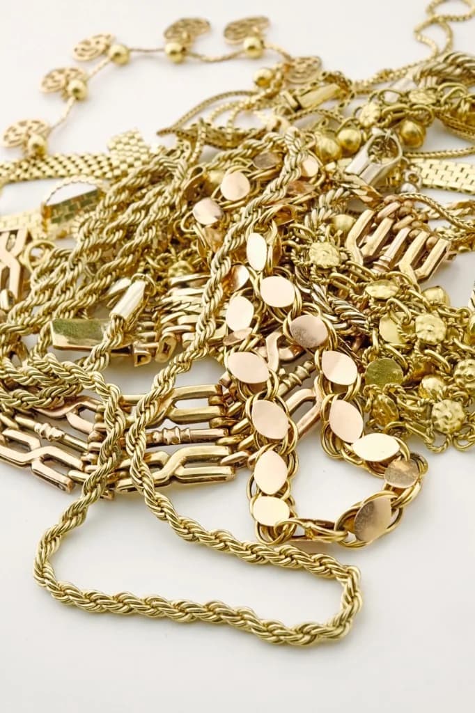 Stapel gouden sieraden, kettingen, armbanden en hangers voor taxatie en inkoop van sloopgoud in Nederland